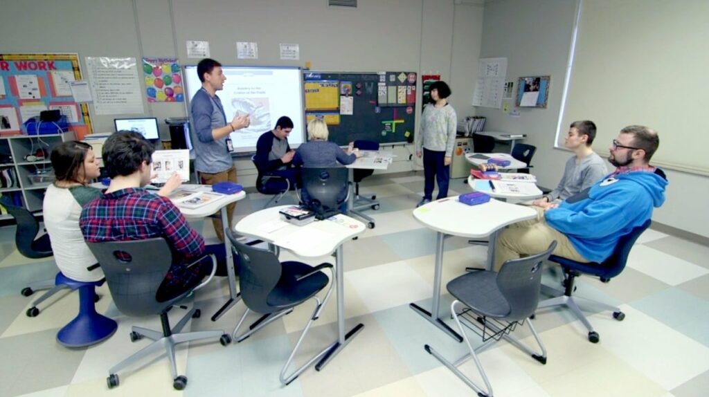 Erlind-Header high school special education teacher works with students in a classroom.