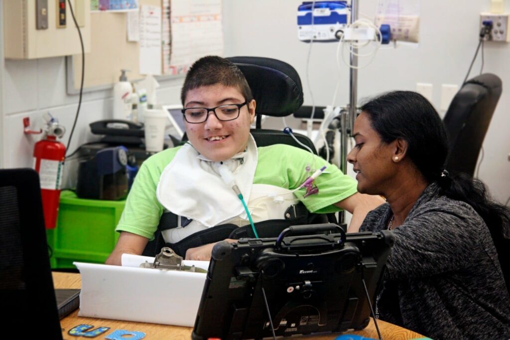 Not Feeling Quite Write Building Wings Building Wings Teacher works with a student in a wheelchair with complex needs