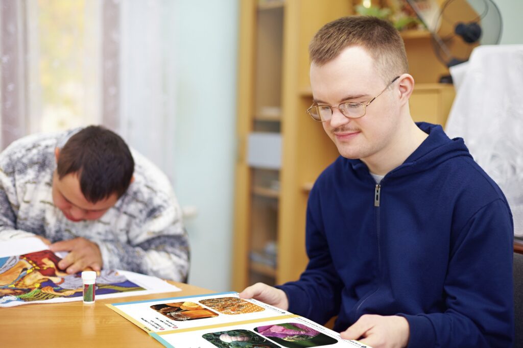 A student in a blue hoodie reads a Readtopia book in their home.