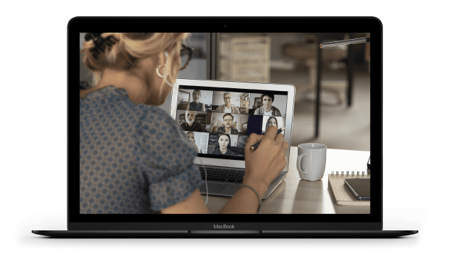 A laptop screen displays a women in a group video meeting
