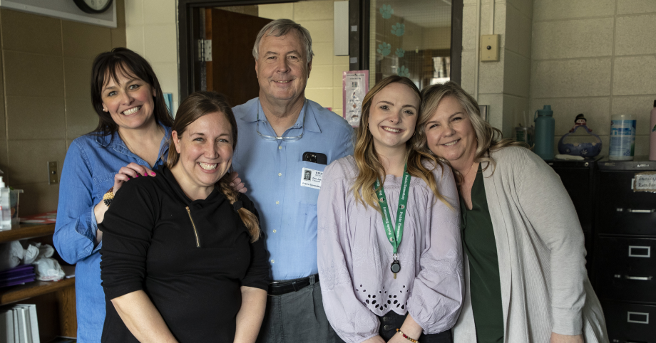 Four female educators pose with a smile for the camera with Don Johnston.