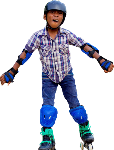 A young boy wearing a blue plaid shirt, rollerblades, helmet, and protective padding smiles at the camera.