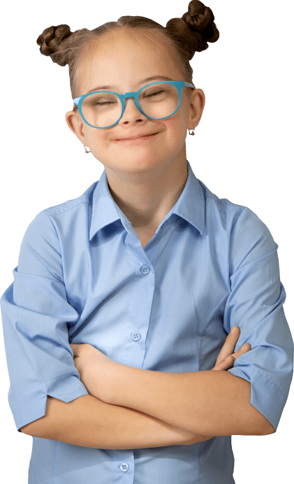 A young girl in a blue button down shirt, with blue glasses, and her hair in two buns smiles with her eyes closed.