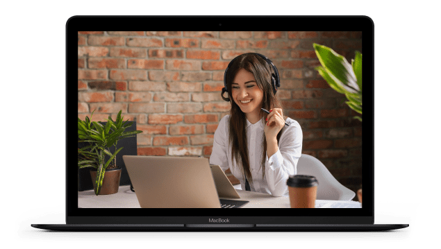 An open MacBook computer shows a girl working at a computer, wearing a headset, on the screen.