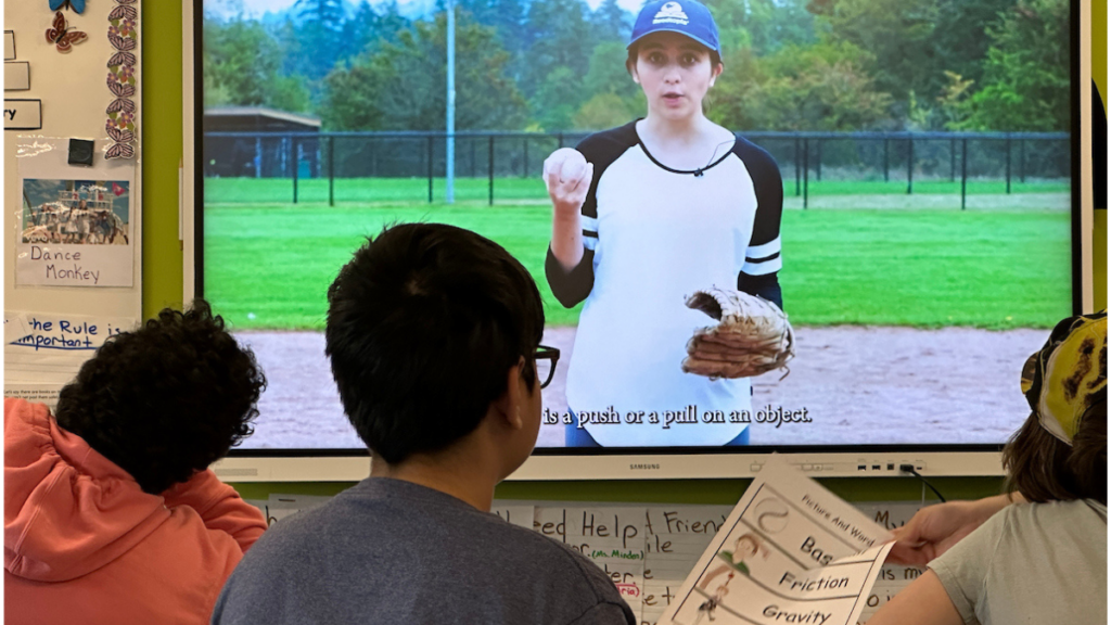 Students watch a baseball video from Casey at the Bat to build background knowledge for a Readtopia literacy lesson.