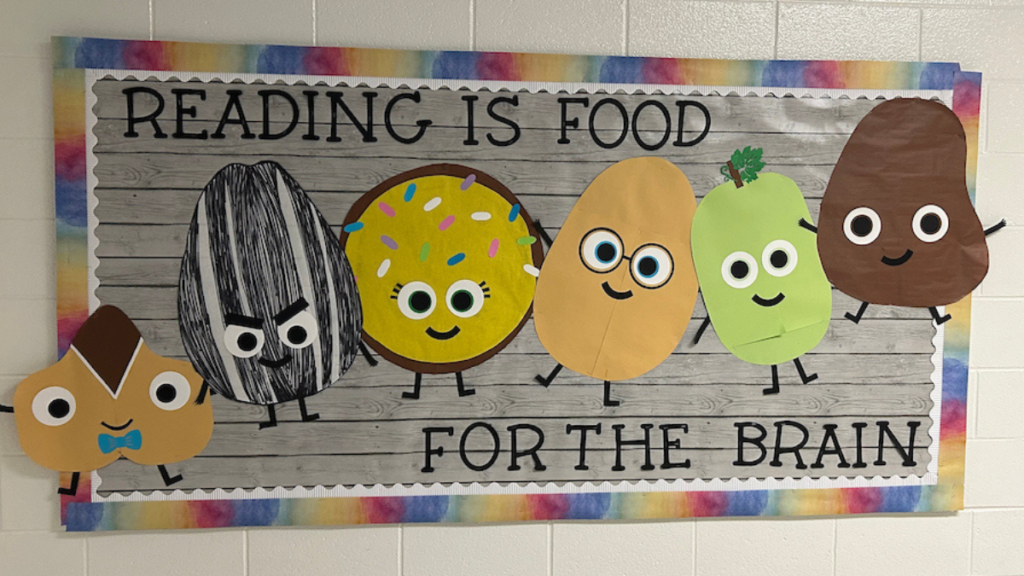 Classroom bulletin board with colorful food characters and the message “Reading is food for the brain.”