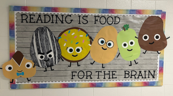 Classroom bulletin board with colorful food characters and the message “Reading is food for the brain.”