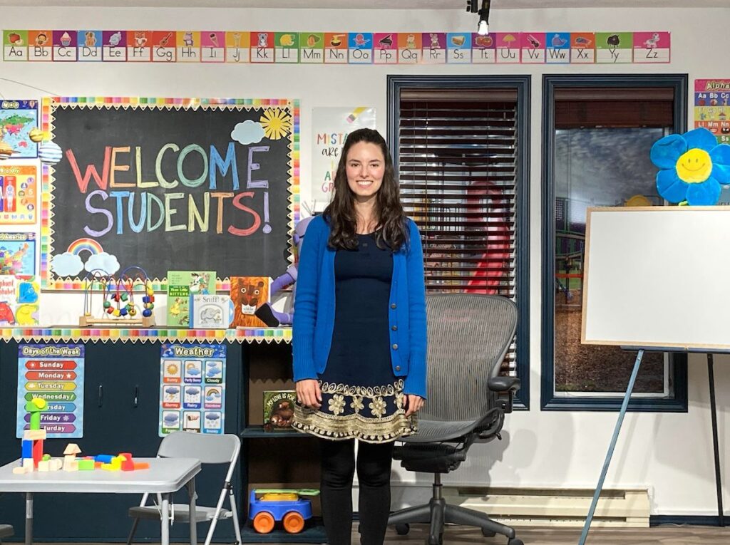 Special educator standing in a colorful classroom prepared for a ReadtopiaGO morning message lesson.