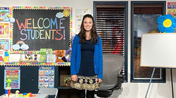 Special educator standing in a colorful classroom prepared for a ReadtopiaGO morning message lesson.