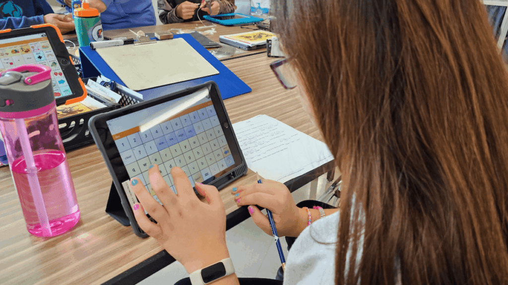 Student using an alternative keyboard on a tablet to write during an inclusive classroom activity.