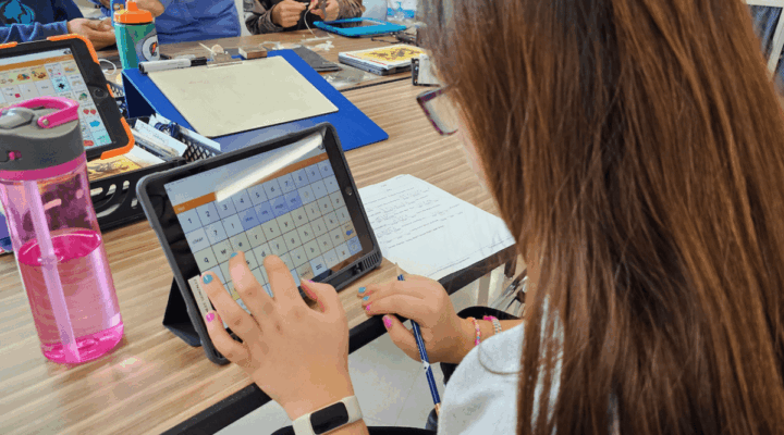 Student using an alternative keyboard on a tablet to write during an inclusive classroom activity.