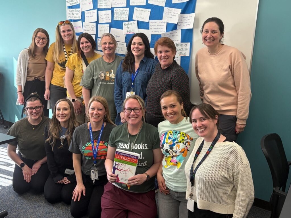 A group of 12 special educators and related service providers gather for a comprehensive literacy book study. One educator holds a copy of Comprehensive Literacy for All.